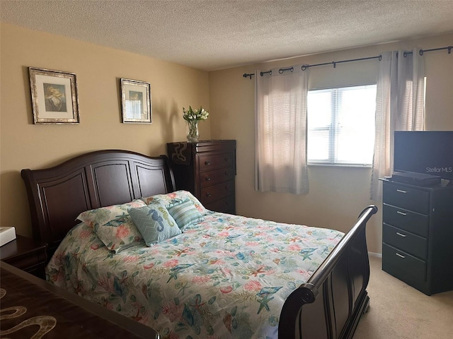 bedroom featuring light colored carpet and a textured ceiling