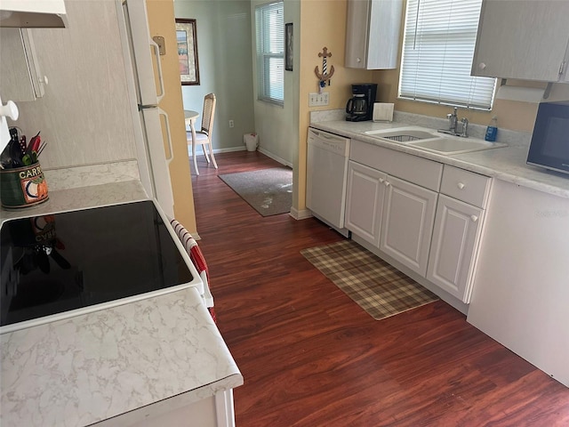 kitchen with white dishwasher, sink, dark hardwood / wood-style floors, white cabinetry, and range hood