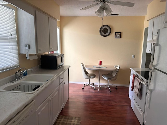 kitchen featuring a textured ceiling, white appliances, dark wood-type flooring, sink, and white cabinetry