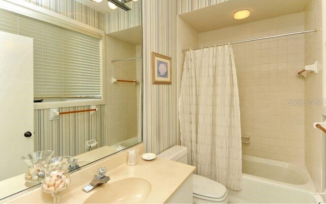 full bathroom featuring vanity, toilet, and shower / bath combo with shower curtain