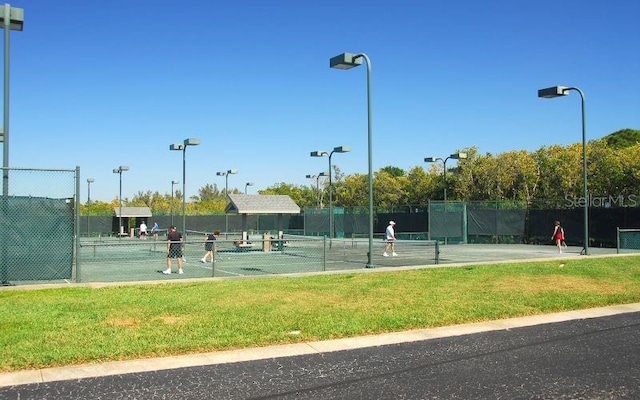 view of sport court featuring a lawn