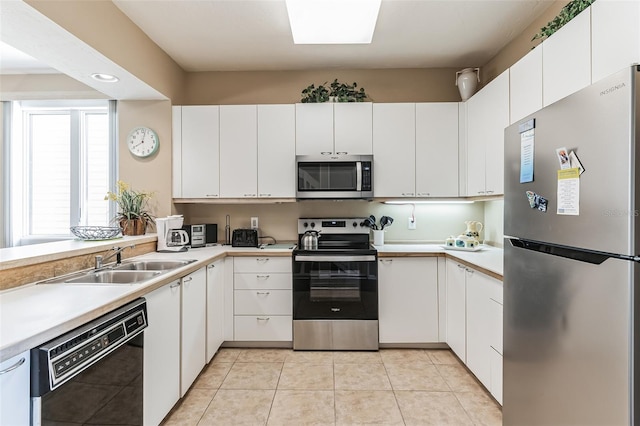 kitchen featuring sink, white cabinetry, stainless steel appliances, and light tile patterned floors