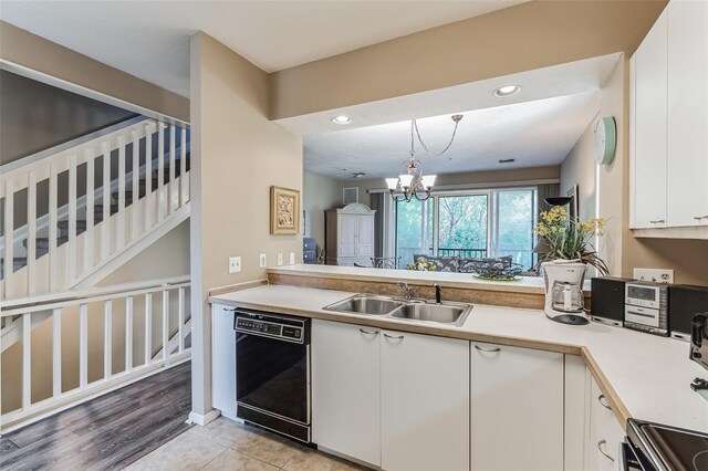 kitchen with sink, pendant lighting, light hardwood / wood-style flooring, white cabinets, and black dishwasher