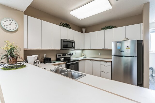 kitchen with white cabinets, stainless steel appliances, and sink