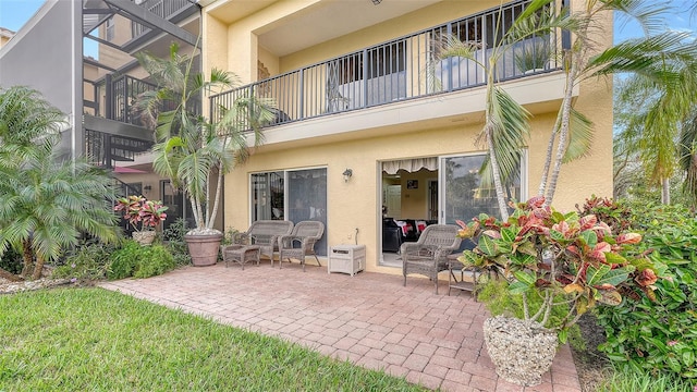 rear view of property with a balcony and a patio area