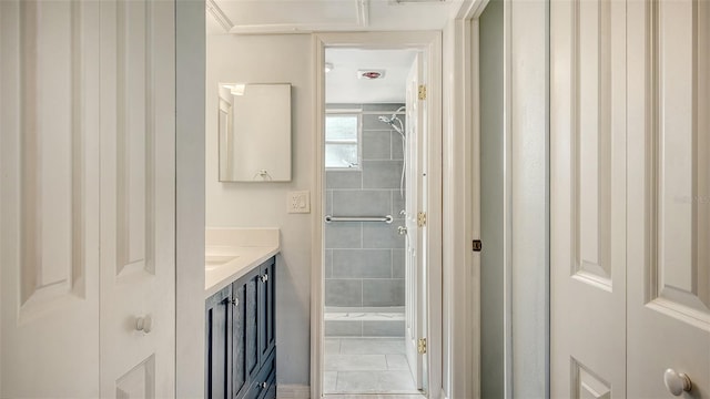 bathroom featuring tiled shower, vanity, and tile patterned floors