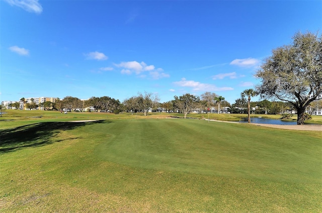 surrounding community featuring a water view and a lawn