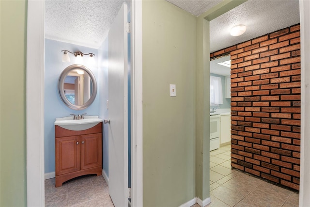 bathroom featuring tile patterned flooring, brick wall, and a textured ceiling