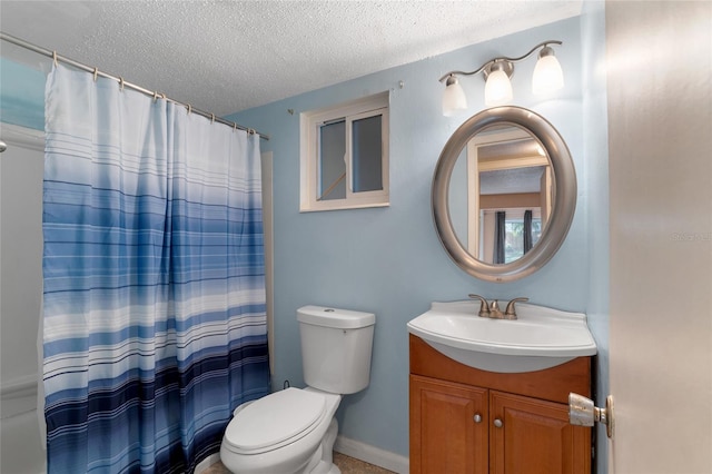 bathroom featuring toilet, vanity, and a textured ceiling