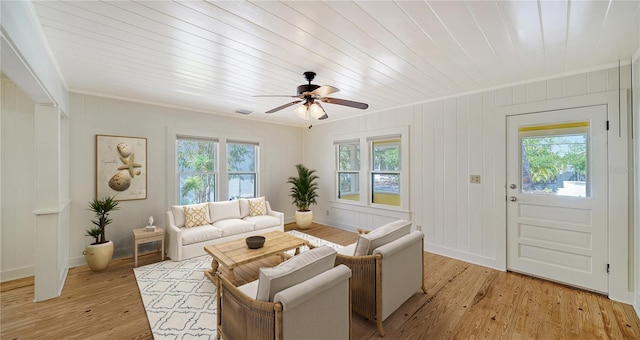 living room with light hardwood / wood-style floors, plenty of natural light, and crown molding