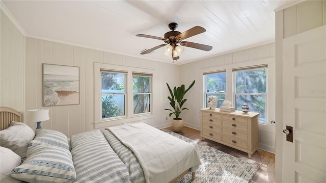 bedroom featuring light wood-type flooring, ceiling fan, and ornamental molding