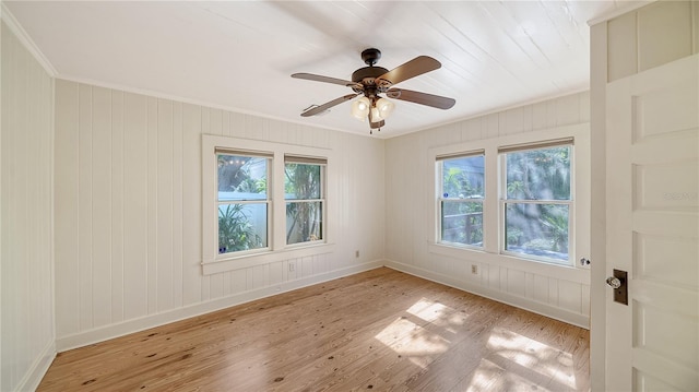 empty room with ceiling fan, light hardwood / wood-style floors, and ornamental molding