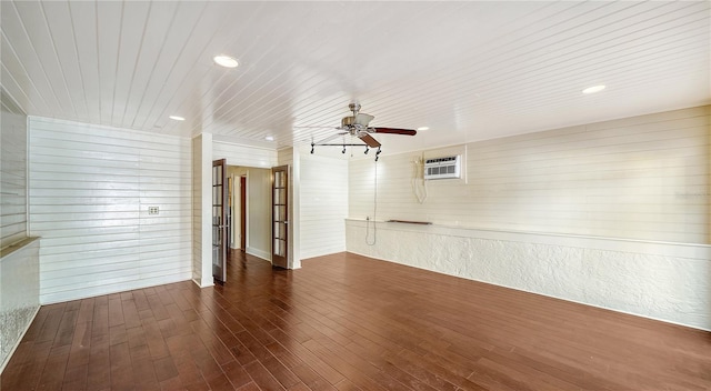 empty room with a wall mounted air conditioner, dark hardwood / wood-style flooring, ceiling fan, and wooden ceiling