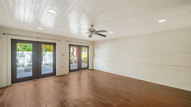 spare room with ceiling fan, a healthy amount of sunlight, dark hardwood / wood-style flooring, and french doors