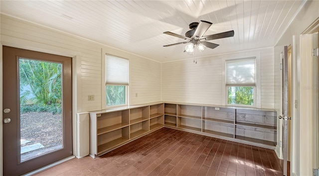 interior space with ceiling fan, dark hardwood / wood-style flooring, and wooden ceiling