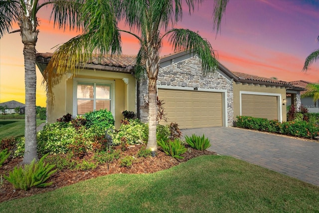 2520 Avolet Ct, Bradenton, FL 34211 - view of front of property with a garage, stone siding, stucco siding, decorative driveway, and a front lawn