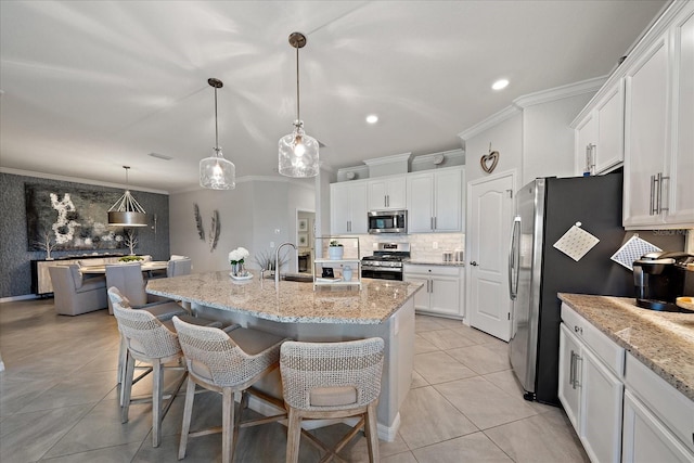 kitchen with a kitchen island with sink, white cabinets, and appliances with stainless steel finishes