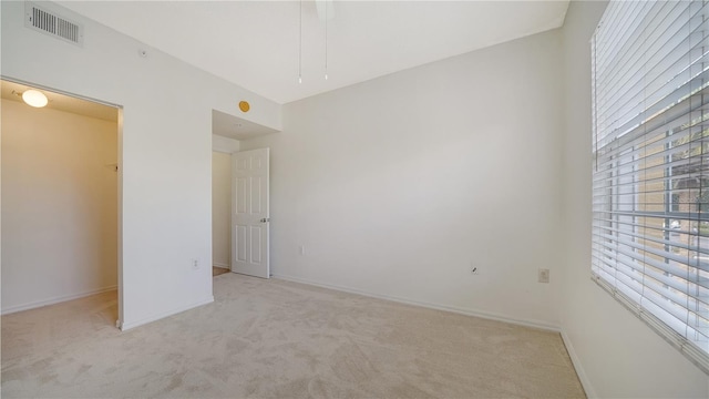 unfurnished bedroom with light colored carpet and multiple windows