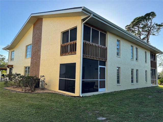 view of side of property with a yard and a sunroom