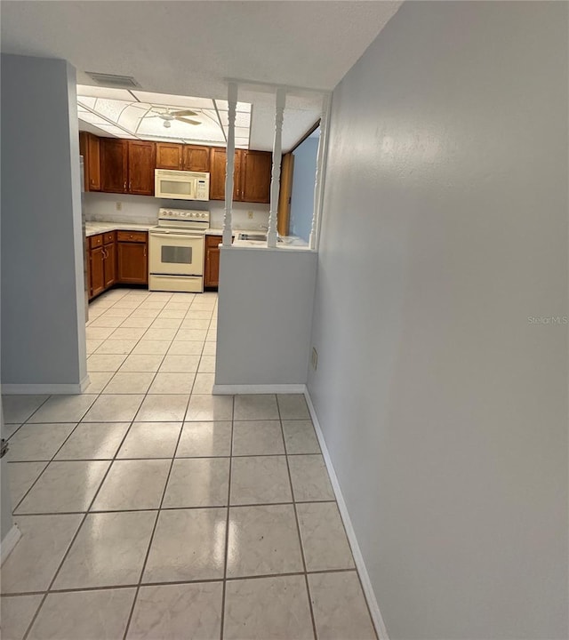 kitchen featuring light tile patterned floors and white appliances