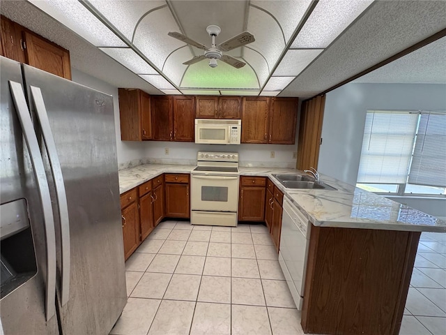 kitchen with kitchen peninsula, white appliances, ceiling fan, sink, and light tile patterned flooring