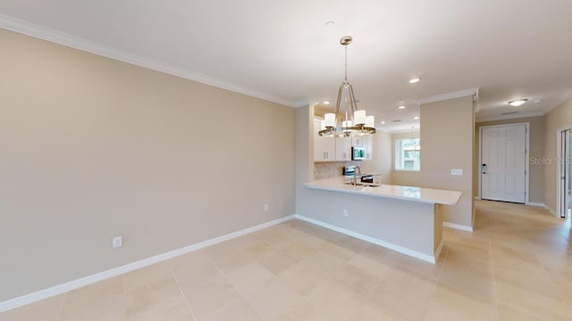 kitchen with white cabinetry, kitchen peninsula, ornamental molding, decorative light fixtures, and decorative backsplash