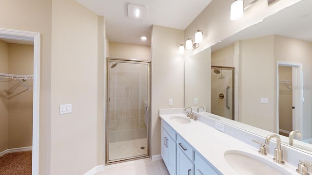 bathroom featuring vanity, a shower with shower door, and tile patterned floors