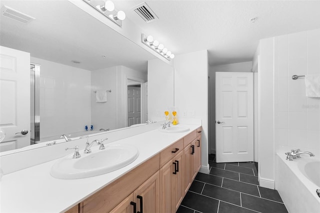 bathroom featuring tile patterned floors, vanity, a textured ceiling, and shower with separate bathtub