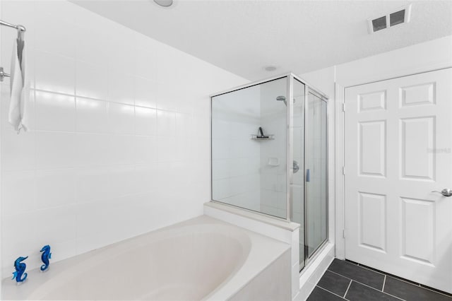 bathroom featuring tile patterned floors, a textured ceiling, and plus walk in shower