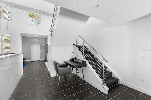 stairway with tile patterned floors and a textured ceiling