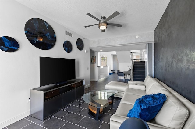 tiled living room featuring ceiling fan and a textured ceiling