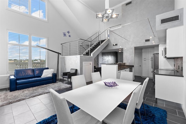 dining room featuring tile patterned flooring, plenty of natural light, stairs, and visible vents