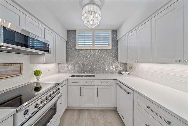 kitchen featuring white cabinets, sink, white dishwasher, range with electric cooktop, and tasteful backsplash