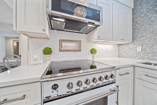 kitchen with decorative backsplash, white cabinetry, and appliances with stainless steel finishes