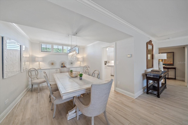 dining space featuring a chandelier, light wood-type flooring, and crown molding