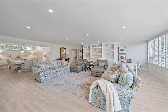 living room featuring light wood-type flooring, a wealth of natural light, and ornamental molding