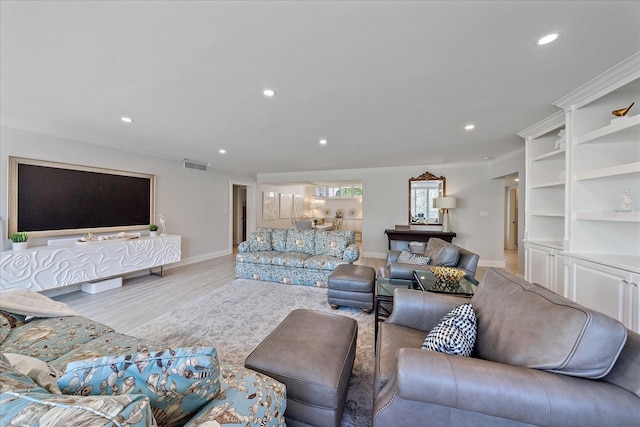 living room with light hardwood / wood-style flooring and ornamental molding