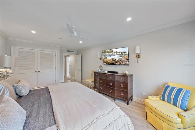 bedroom with crown molding, ceiling fan, a closet, and light hardwood / wood-style floors