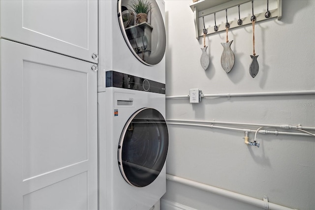 clothes washing area with stacked washer and clothes dryer