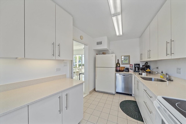 kitchen with white cabinetry, white refrigerator, sink, light tile patterned floors, and dishwasher