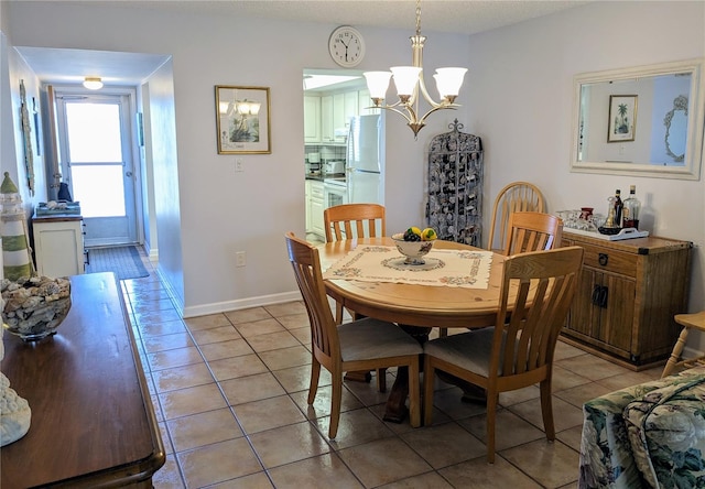 tiled dining space featuring a chandelier