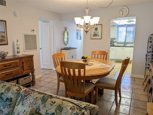 tiled dining space featuring ceiling fan with notable chandelier