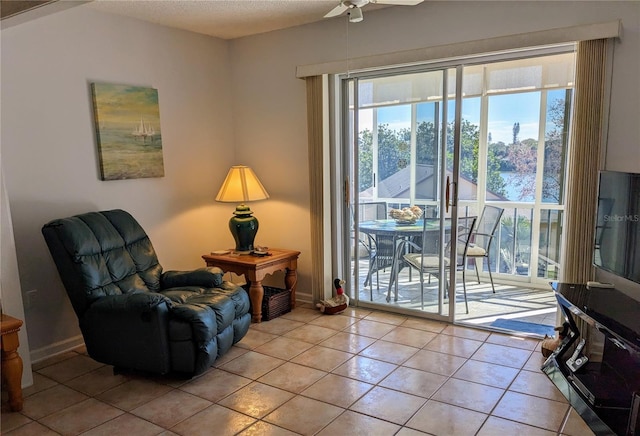 sitting room with ceiling fan and light tile patterned floors