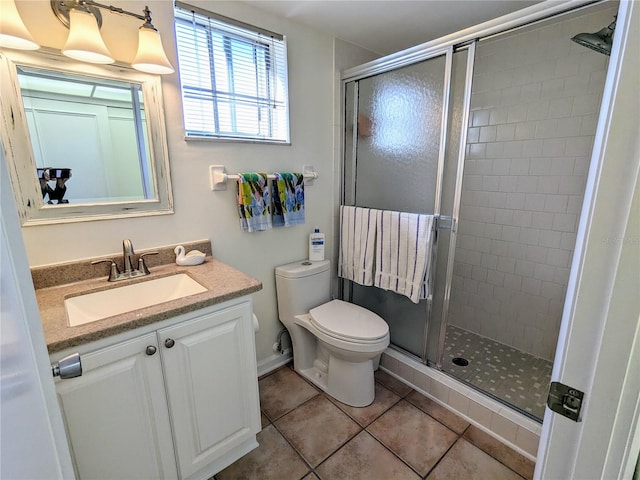 bathroom with toilet, vanity, tile patterned floors, and an enclosed shower