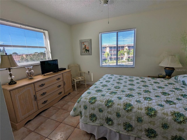 bedroom featuring light tile patterned floors and a textured ceiling