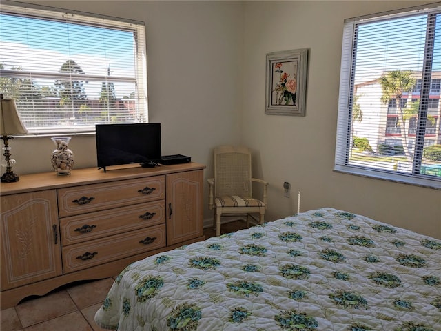 bedroom with light tile patterned floors and multiple windows