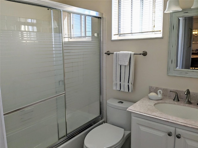 full bathroom featuring vanity, toilet, and bath / shower combo with glass door