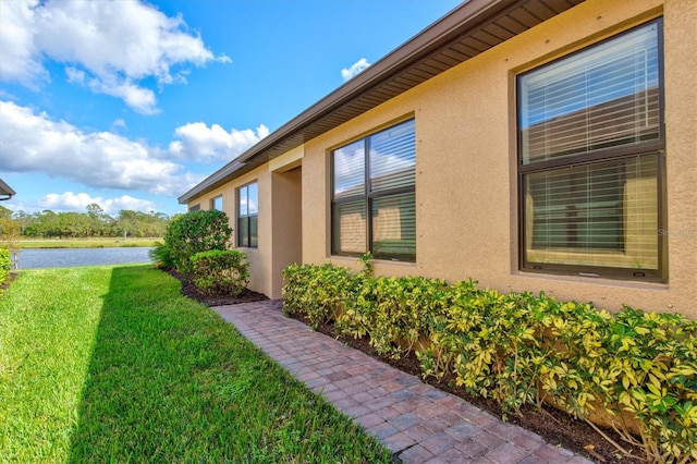 view of property exterior featuring a yard and a water view