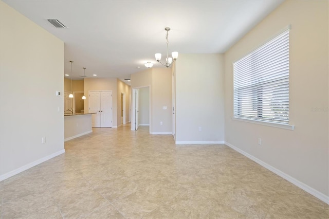 spare room with a notable chandelier