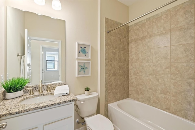 full bathroom featuring tiled shower / bath combo, toilet, and vanity